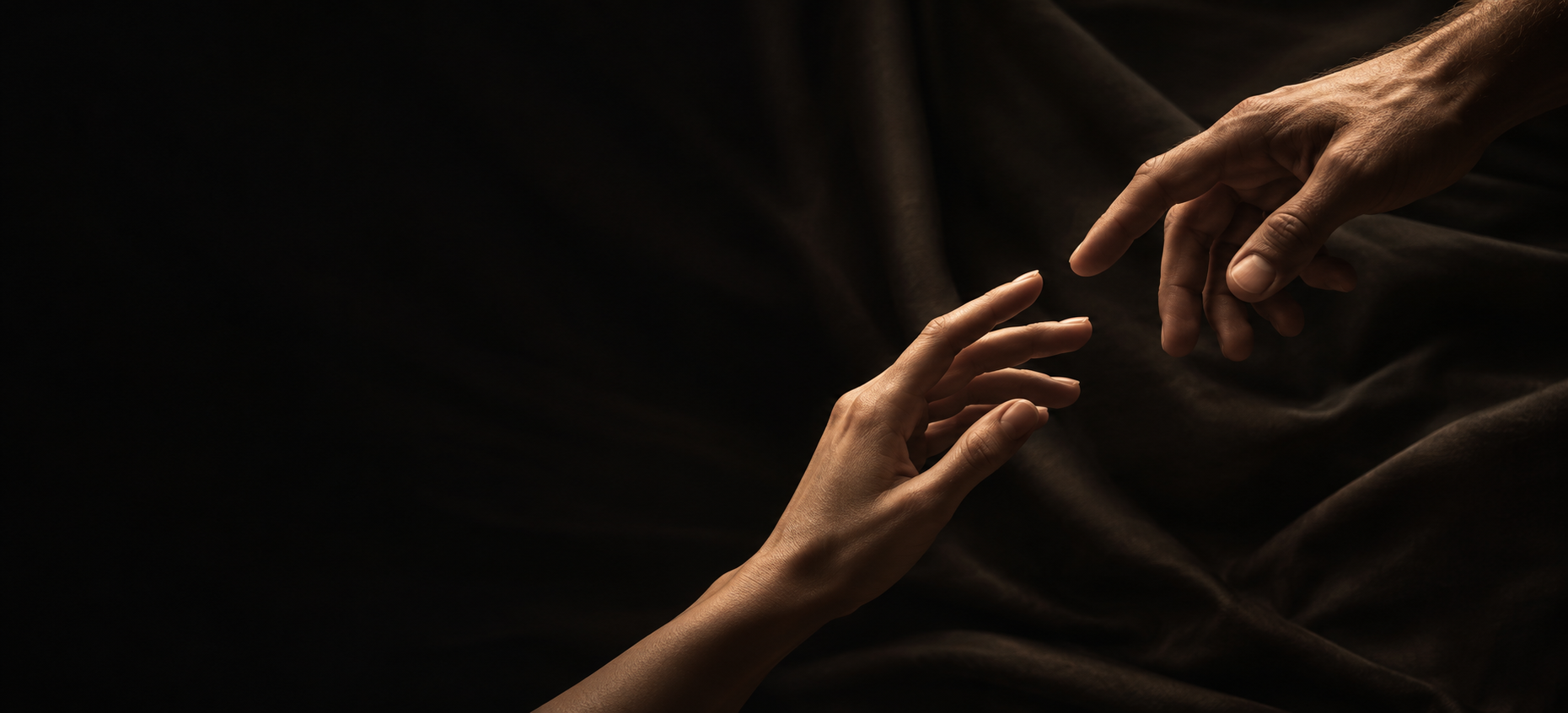 Dos manos acercándose sobre una tela oscura